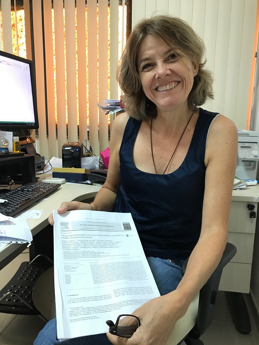 Sandra Santos mostra a publicação, em inglês, que indica como medir a sustentabilidade em áreas complexas - Foto: Ana Maio